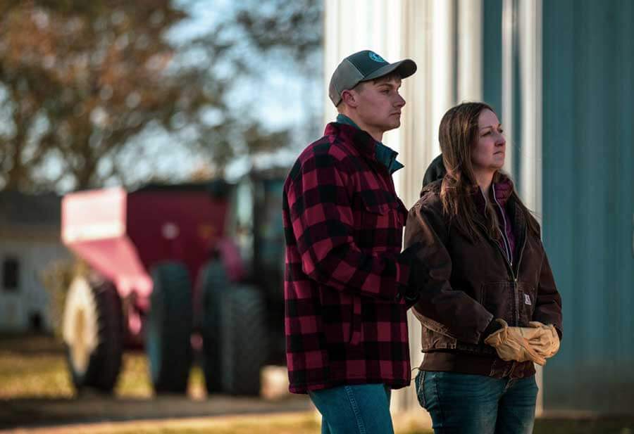 Dane Kruse standing with woman in front of tractor